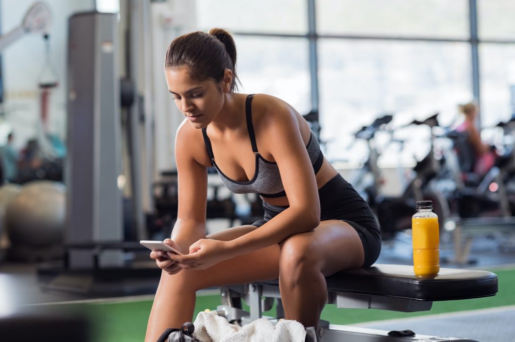 Woman using phone at gym