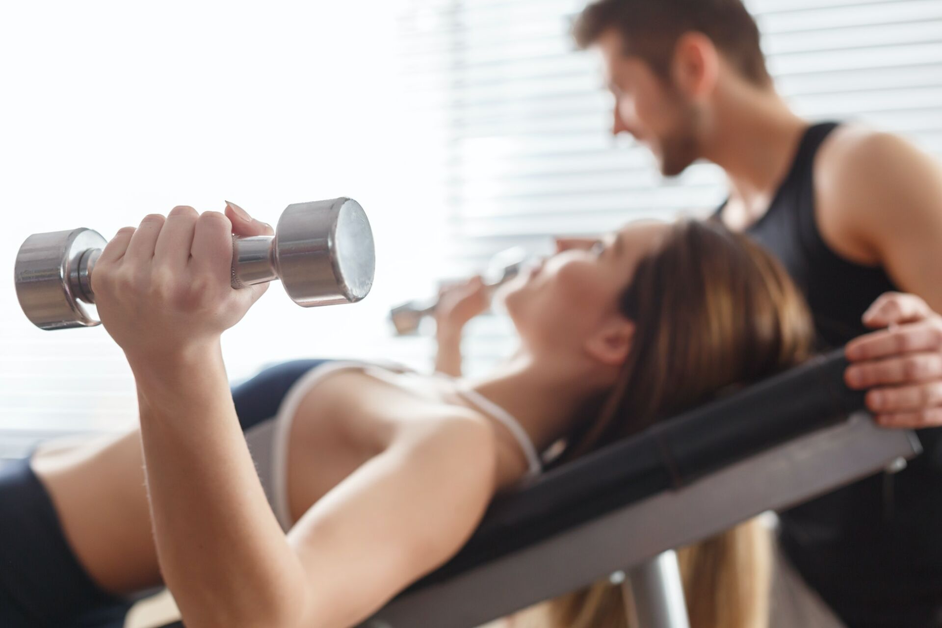 Woman lying with dumbbells