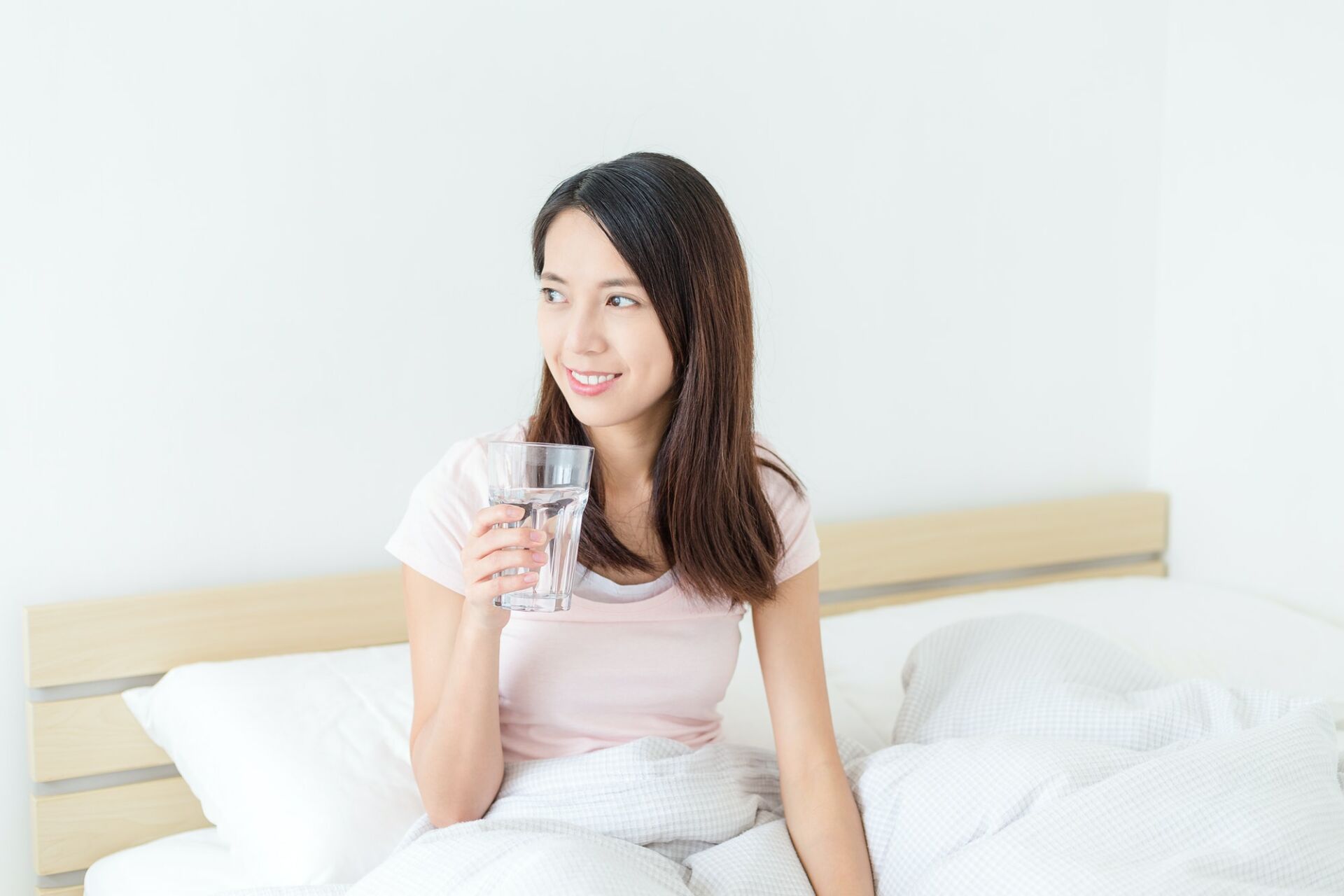 Woman drink water on bed