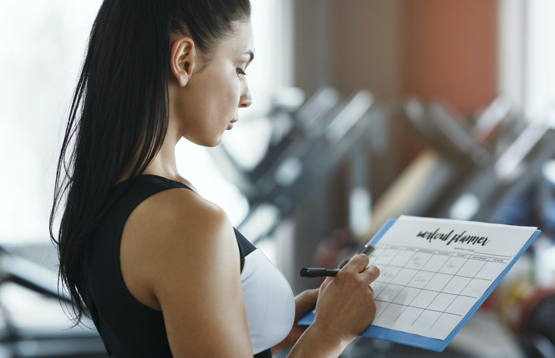 Personal trainer with clipboard making workout plan in gym