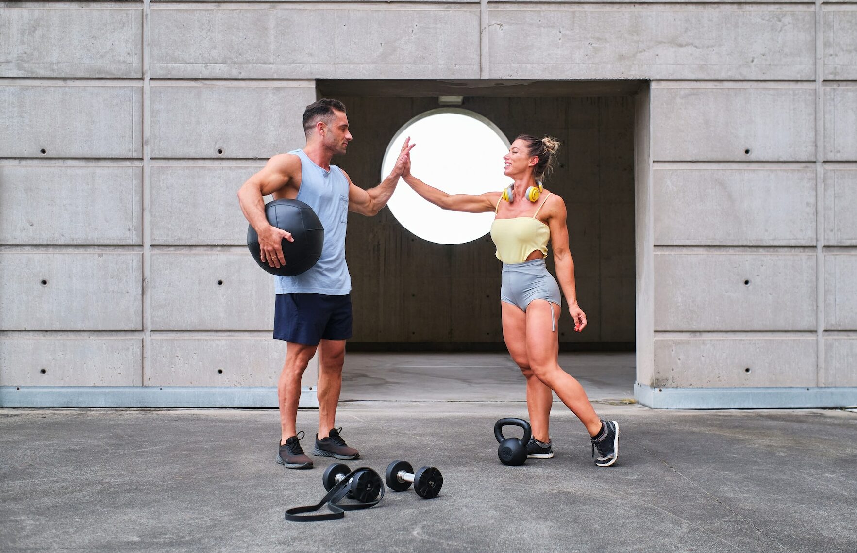An athlete couple giving high five together after workout in Sustainable Fitness Routine