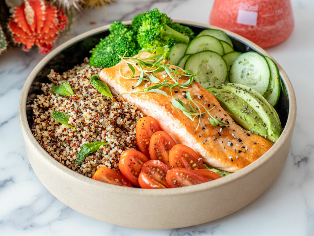 Plate of salmon with quinoa and raw vegetables